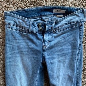 Boot cut jeans with frayed bottoms.